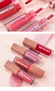 Close-up of velvet lip gloss set with brush applicator detail and pink ribbon decoration