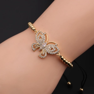 Macro shot of adjustable golden butterfly bracelet with cubic zirconia on black cord