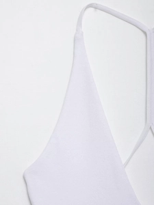 Detail view of white knit bodysuit showing fine stitching on the thin shoulder strap
