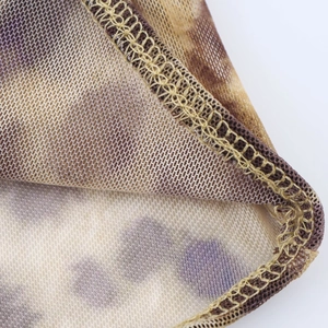 Close-up of sheer mesh fabric with purple and brown floral pattern and stitching detail