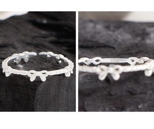 Detail view of S925 sterling silver bow ring featuring an adjustable open band design