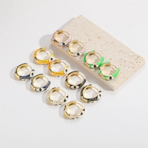 Detailed macro shot of enamel evil eye earrings in various colors on stone display