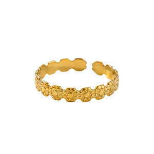 Detailed close-up of gold adjustable ring featuring repetitive floral petal patterns