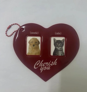 Macro shot of dark red heart photo frame keychain with white Cherish you script