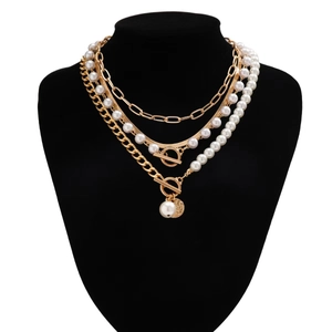 Detail of multilayer gold chain and baroque pearl necklace set on a black neck model