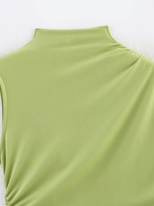 Dettaglio del top senza maniche verde erba a collo alto che mostra la trama del tessuto