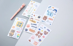Close-up of cute cartoon stationery set including stickers and a pink reindeer gel pen