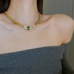 Detail des Schlangenkopf-Verschlusses mit grünen Steinen und Zirkonia auf Goldkette
