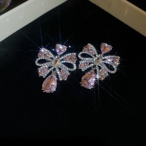 Détail des boucles d'oreilles nœud en cristal rose avec pendentifs goutte d'eau