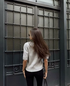 Vue arrière montrant la coupe ajustée et le drapé de ce pull en tricot gris à manches courtes