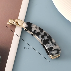 Detail showing 11cm acetate banana hair clip with black and white marble pattern