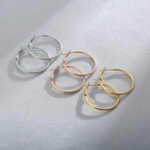 Textured hoop earrings in gold, silver and rose gold finishes with spiral pattern details