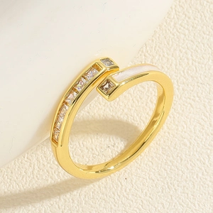Macro detail of gold open ring featuring square zircons and white enamel inlay