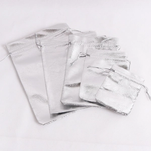 Five assorted sizes of metallic silver drawstring jewelry pouches in a tiered layout