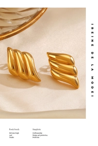 Close-up of golden spiral earrings on elegant satin background with premium metallic finish
