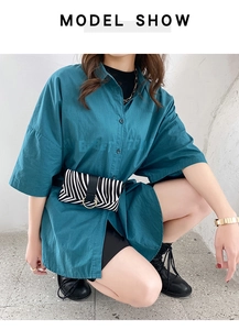 Detail of zebra print waist bag with gold ring buckle on an oversized shirt