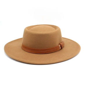 Detail of flat-top wool felt hat with brown leather belt buckles and metal rivets