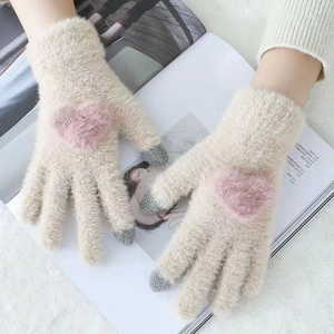 Detailed view of beige knit plush gloves with pink heart and touch screen fingertips