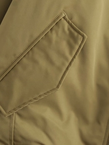 Gros plan détaillé sur la poche de la veste aviateur vert olive et ses coutures de qualité