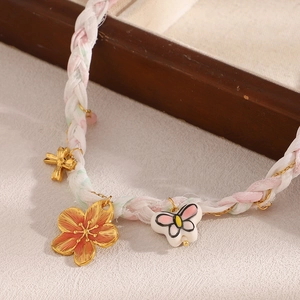 Collier tressé rose et blanc avec chaîne dorée, pendentifs fleur et papillon