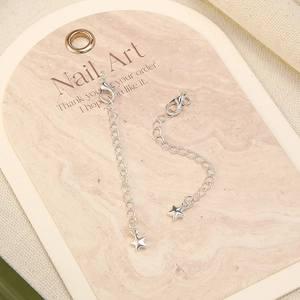 Macro shot of silver extension chains with lobster clasp and star charm for jewelry making