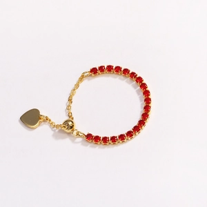 Detailed view of adjustable gold chain ring with red round gems and a heart pendant