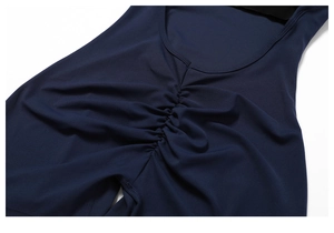 Macro detail of dark blue ruched stretch fabric showing professional stitching and texture
