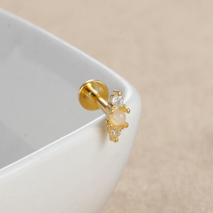 Macro d'un piercing labret doré avec pierre d'opale et diamants brillants