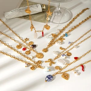 Detaillierte Ansicht goldener Charme-Halsketten mit Perlen und Keramikherzen im Set