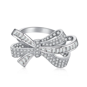Elegant silver bow ring with sparkling zircons on a white background with reflection