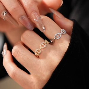 Macro detail of gold and silver chain link rings with micro-pave cubic zirconia stones