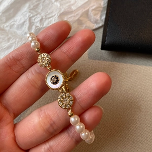 Détail du bracelet de perles plaqué or 18 carats avec œil en zircon et breloques étoile