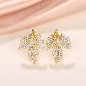 Close-up of gold-plated leaf stud earrings with sparkling pave-set micro zircons