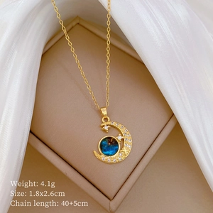 Detail of gold moon and star pendant necklace with blue gem on beige jewelry box