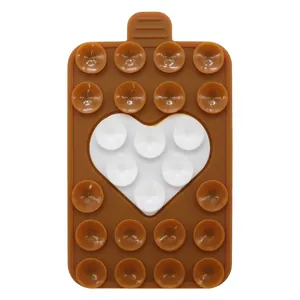 Detail of a brown rectangular silicone suction cup phone holder with white heart pattern
