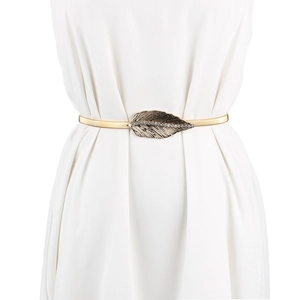 Détail d'une ceinture élastique dorée avec une boucle en forme de feuille ornée de strass