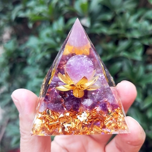 Macro shot of an Orgonite pyramid with amethyst, gold foil, and lotus crystal ball