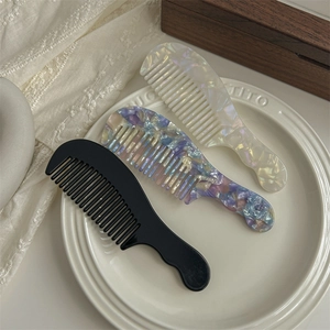 Tortoise shell acetate wide tooth hair combs in marble colors on decorative tray