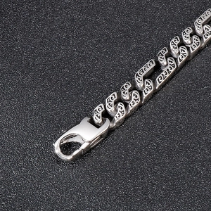 Macro shot of retro pattern links and lobster clasp on silver titanium steel bracelet