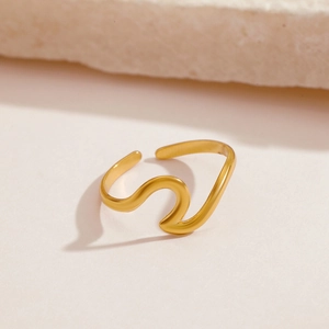 Minimalist wave-shaped open ring in gold stainless steel on elegant stone background