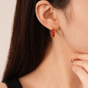 Detail of red zircon wheat ear U-shaped earrings on model for an elegant luxury style