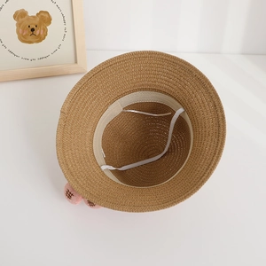 Detail of children's straw hat showing inner lining, elastic chin strap and bear ears