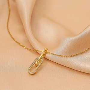 Collier en titane doré avec pendentif double anneau serti de zircons sur soie luxueuse