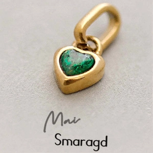 Close-up of a heart-shaped gold pendant featuring a vibrant green birthstone detail