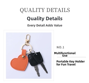 Detail of orange heart-shaped leather keychain with lychee texture and gold spring hook