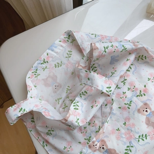 Detail of floral tote bag with pink roses, blue bows, and cute teddy bear patterns
