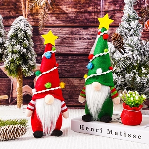 Festive red and green Christmas gnomes with tall star hats and white beards on a cozy table