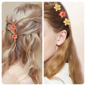 Detail of 4cm candy-colored plumeria hair claws in red and yellow resin on hair