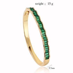 Detail view of wavy 18k gold plated bangle with green zircon stones and 5.7mm width spec