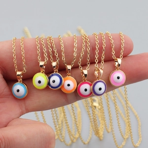 Handheld view of seven colorful evil eye pendants with gold chains in various vibrant hues